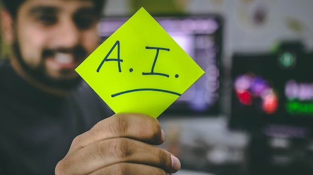 a person holding a post-it with the word A.I.